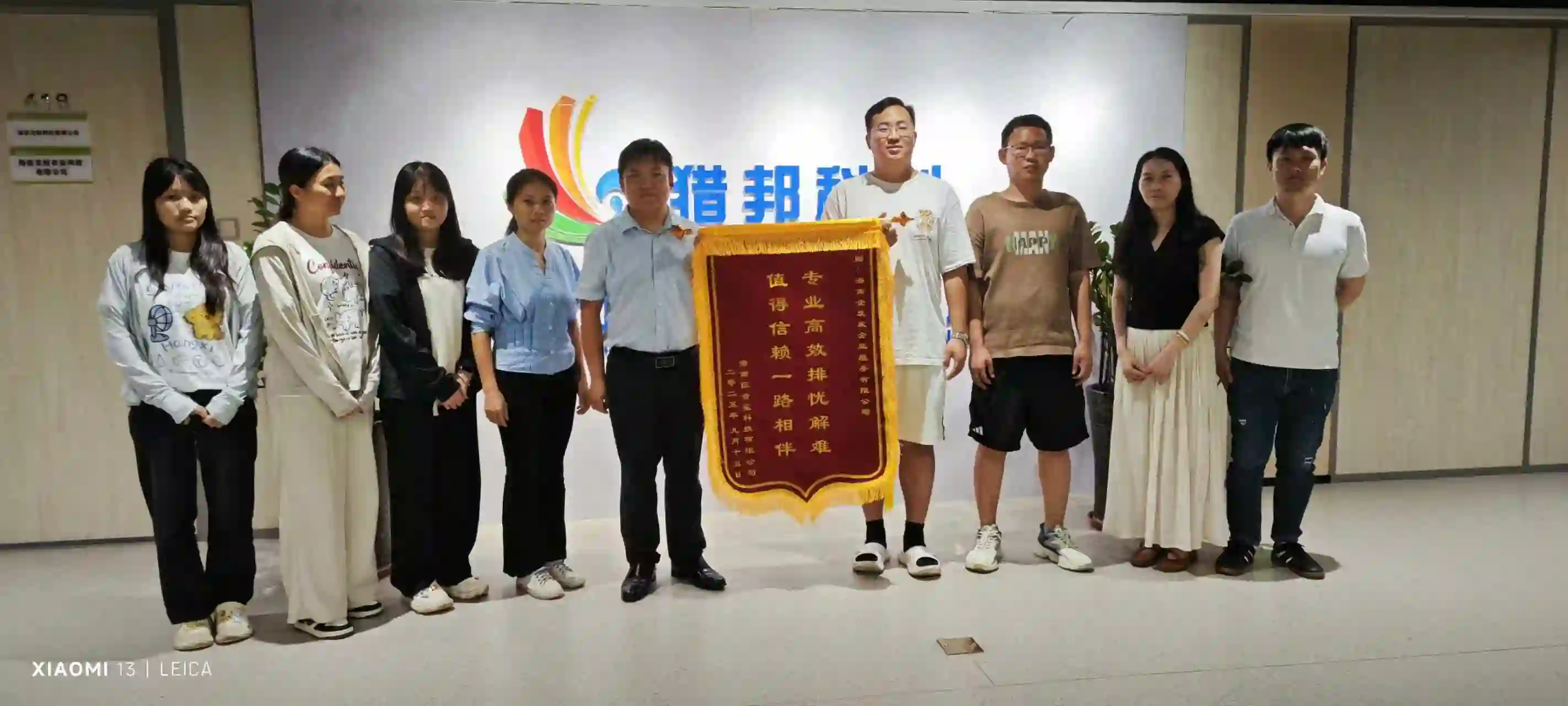 Hainan Setup team receiving a client appreciation banner for company registration services